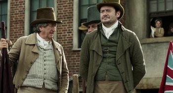 Movie still from “Peterloo” (2018), directed by Mike Leigh – A group of men standing next to each other wearing hats; Medium shot, Over the shoulder angle