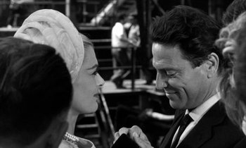 Movie still from “Phaedra” (1962), directed by Jules Dassin – A black and white photo of a man and a woman smiling; Close Up shot, Over the shoulder angle