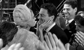 Movie still from “Phaedra” (1962), directed by Jules Dassin – A man and a woman smiling at each other; Close Up shot, Over the shoulder angle