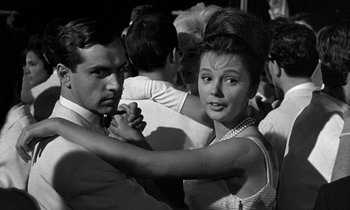 Movie still from “Phaedra” (1962), directed by Jules Dassin – A man and a woman dancing in a crowd; Medium shot, Low angle