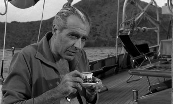Movie still from “Phaedra” (1962), directed by Jules Dassin – A black and white photo of a man holding a coffee cup; Close Up shot, Low angle