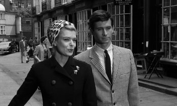 Movie still from “Phaedra” (1962), directed by Jules Dassin – A man and a woman standing next to each other on the street; Medium shot, Over the shoulder angle