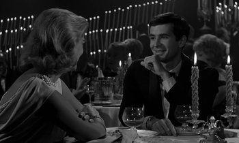 Movie still from “Phaedra” (1962), directed by Jules Dassin – A man and a woman sitting at a dinner table; Medium shot, Over the shoulder angle