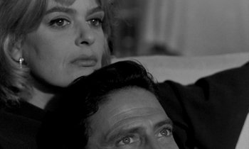 Movie still from “Phaedra” (1962), directed by Jules Dassin – A man and a woman sitting next to each other on a couch; Close Up shot, High angle