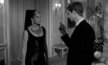 Movie still from “Phaedra” (1962), directed by Jules Dassin – A man and a woman are standing next to each other; Medium shot, Over the shoulder angle