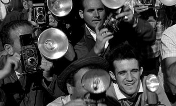 Movie still from “Phaedra” (1962), directed by Jules Dassin – A black and white photo of a group of men; Extreme Close Up shot, High angle