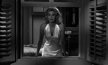 Movie still from “Phaedra” (1962), directed by Jules Dassin – A black and white photo of a woman looking out of a window; Medium shot, Low angle