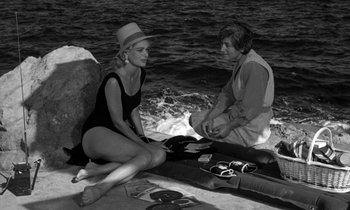 Movie still from “Phaedra” (1962), directed by Jules Dassin – Two women sitting on the shore of the ocean; Medium shot, High angle