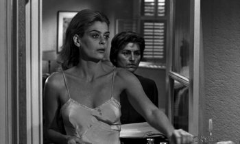 Movie still from “Phaedra” (1962), directed by Jules Dassin – A man and a woman sitting next to each other in a room; Medium shot, Low angle