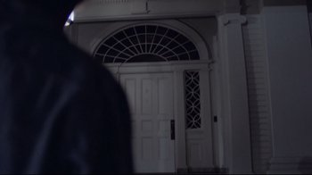 Movie still from “Phantasm” (1979), directed by Don Coscarelli – A white door with an arched window in the center; Medium shot, Low angle