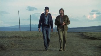 Movie still from “Phase IV” (1974), directed by Saul Bass – Two men are walking in the dirt together; Wide shot, Low angle