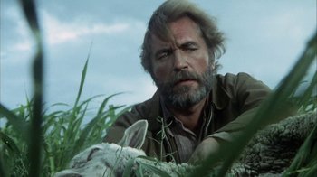 Movie still from “Phase IV” (1974), directed by Saul Bass – A man with long hair and a beard is holding a sheep; Close Up shot, Low angle