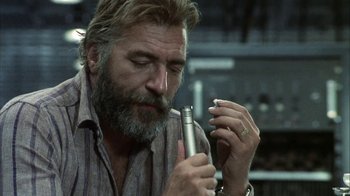 Movie still from “Phase IV” (1974), directed by Saul Bass – An older man with a beard and mustache holding an electronic device; Close Up shot, Low angle