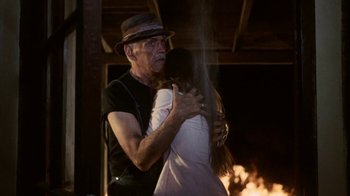 Movie still from “Phase IV” (1974), directed by Saul Bass – An old man and a young woman hugging in front of a fire; Medium shot, Low angle