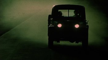 Movie still from “Phase IV” (1974), directed by Saul Bass – A truck driving down a street at night with headlights on; Wide shot, Low angle