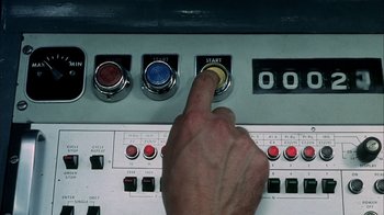 Movie still from “Phase IV” (1974), directed by Saul Bass – A hand is pressing a button on an electrical panel; Extreme Close Up shot, Overhead angle