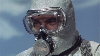 Movie still from “Phase IV” (1974), directed by Saul Bass – A man in a silver suit wearing a gas mask; Close Up shot, Low angle