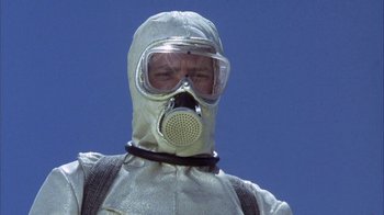 Movie still from “Phase IV” (1974), directed by Saul Bass – A man wearing a gas mask and a suit; Close Up shot, Low angle