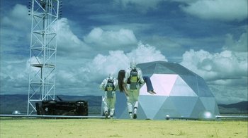 Movie still from “Phase IV” (1974), directed by Saul Bass – A couple of people that are standing in the grass; Extreme Wide shot, Low angle