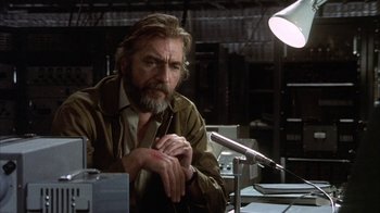 Movie still from “Phase IV” (1974), directed by Saul Bass – A man sitting at a table in a room; Close Up shot, Low angle