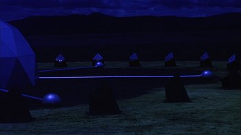 Movie still from “Phase IV” (1974), directed by Saul Bass – A group of rocks sitting on top of a grass covered field; Extreme Wide shot, High angle