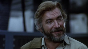 Movie still from “Phase IV” (1974), directed by Saul Bass – An older man with a goatee is smiling; Close Up shot, Low angle