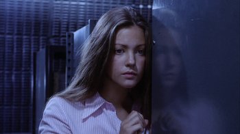 Movie still from “Phase IV” (1974), directed by Saul Bass – A woman in a pink shirt is standing next to a window; Close Up shot, Low angle