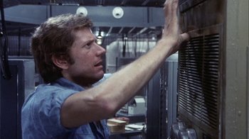 Movie still from “Phase IV” (1974), directed by Saul Bass – A man in a blue shirt is working in an industrial kitchen; Close Up shot, Low angle