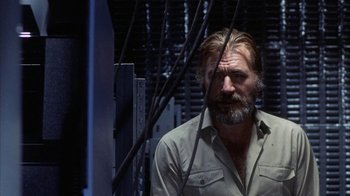 Movie still from “Phase IV” (1974), directed by Saul Bass – A man with a gray beard is looking at the camera; Medium shot, Low angle