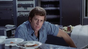 Movie still from “Phase IV” (1974), directed by Saul Bass – A person sitting in front of a plate of food; Close Up shot, Over the shoulder angle