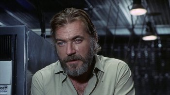 Movie still from “Phase IV” (1974), directed by Saul Bass – A person with a beard wearing a green shirt; Close Up shot, Low angle