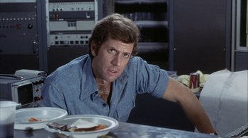 Movie still from “Phase IV” (1974), directed by Saul Bass – A man sitting at a table with a plate in front of him; Close Up shot, Over the shoulder angle
