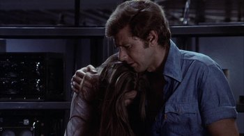 Movie still from “Phase IV” (1974), directed by Saul Bass – A man and a woman embracing each other in front of a building; Close Up shot, Over the shoulder angle