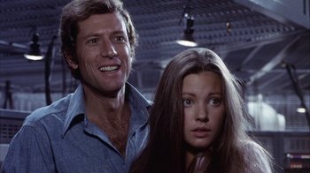 Movie still from “Phase IV” (1974), directed by Saul Bass – A man standing next to a woman in a room; Close Up shot, Low angle