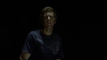 Movie still from “Phase IV” (1974), directed by Saul Bass – A man in a black shirt is standing in the dark; Close Up shot, Low angle