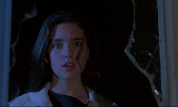 Movie still from “Phenomena” (1985), directed by Dario Argento – A young woman with long black hair standing under an umbrella in the dark; Close Up shot, Low angle