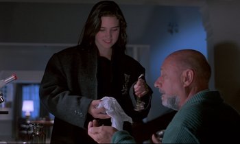 Movie still from “Phenomena” (1985), directed by Dario Argento – A man and a woman are holding tissues; Medium shot, Over the shoulder angle