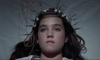 Movie still from “Phenomena” (1985), directed by Dario Argento – A young girl with wires on her head; Close Up shot, Overhead angle