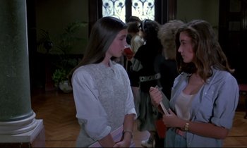 Movie still from “Phenomena” (1985), directed by Dario Argento – Two young women standing next to each other in a room; Medium shot, Over the shoulder angle