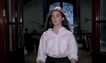 Movie still from “Phenomena” (1985), directed by Dario Argento – A young woman in a white shirt and black skirt; Medium shot, Low angle