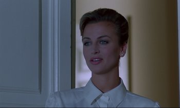 Movie still from “Phenomena” (1985), directed by Dario Argento – A woman in a white dress shirt is looking at the camera; Close Up shot, Over the shoulder angle