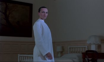 Movie still from “Phenomena” (1985), directed by Dario Argento – A man in a white lab coat standing in a room; Medium shot, Low angle