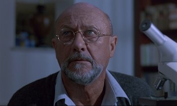 Movie still from “Phenomena” (1985), directed by Dario Argento – An older man with a beard and glasses; Close Up shot, Low angle