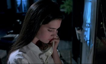 Movie still from “Phenomena” (1985), directed by Dario Argento – A woman with long black hair talking on a phone; Close Up shot, High angle