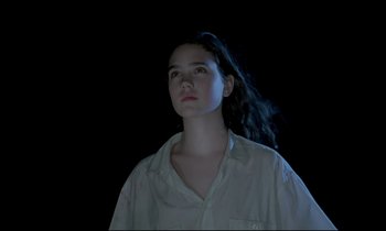 Movie still from “Phenomena” (1985), directed by Dario Argento – A woman in a white shirt is looking up; Close Up shot, Low angle