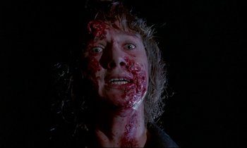 Movie still from “Phenomena” (1985), directed by Dario Argento – A man with a lot of blood on his face; Close Up shot, Low angle