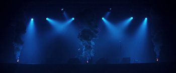 Movie still from “Songs for While I'm Away” (2020), directed by Emer Reynolds – Smoke billows out of a cloud of smoke in the dark; Extreme Wide shot, Low angle