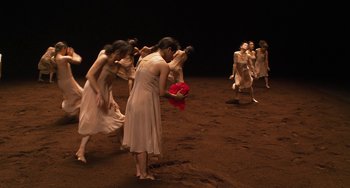 Movie still from “Pina” (2011), directed by Wim Wenders – A group of people in a field with a red object; Wide shot, High angle
