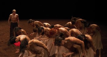 Movie still from “Pina” (2011), directed by Wim Wenders – A group of people are in the sand; Extreme Wide shot, High angle