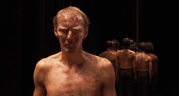 Movie still from “Pina” (2011), directed by Wim Wenders – A man with a lot of dirt all over his face; Close Up shot, Low angle